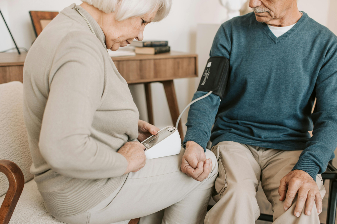 woman checking man's blood pressure at home